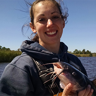 A scientist holding a catfish.